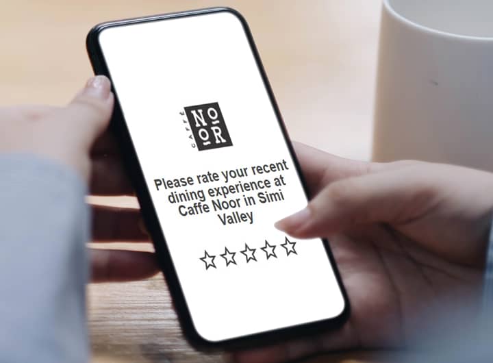 A woman rating her recent dining experience after scanning a QR code on the table